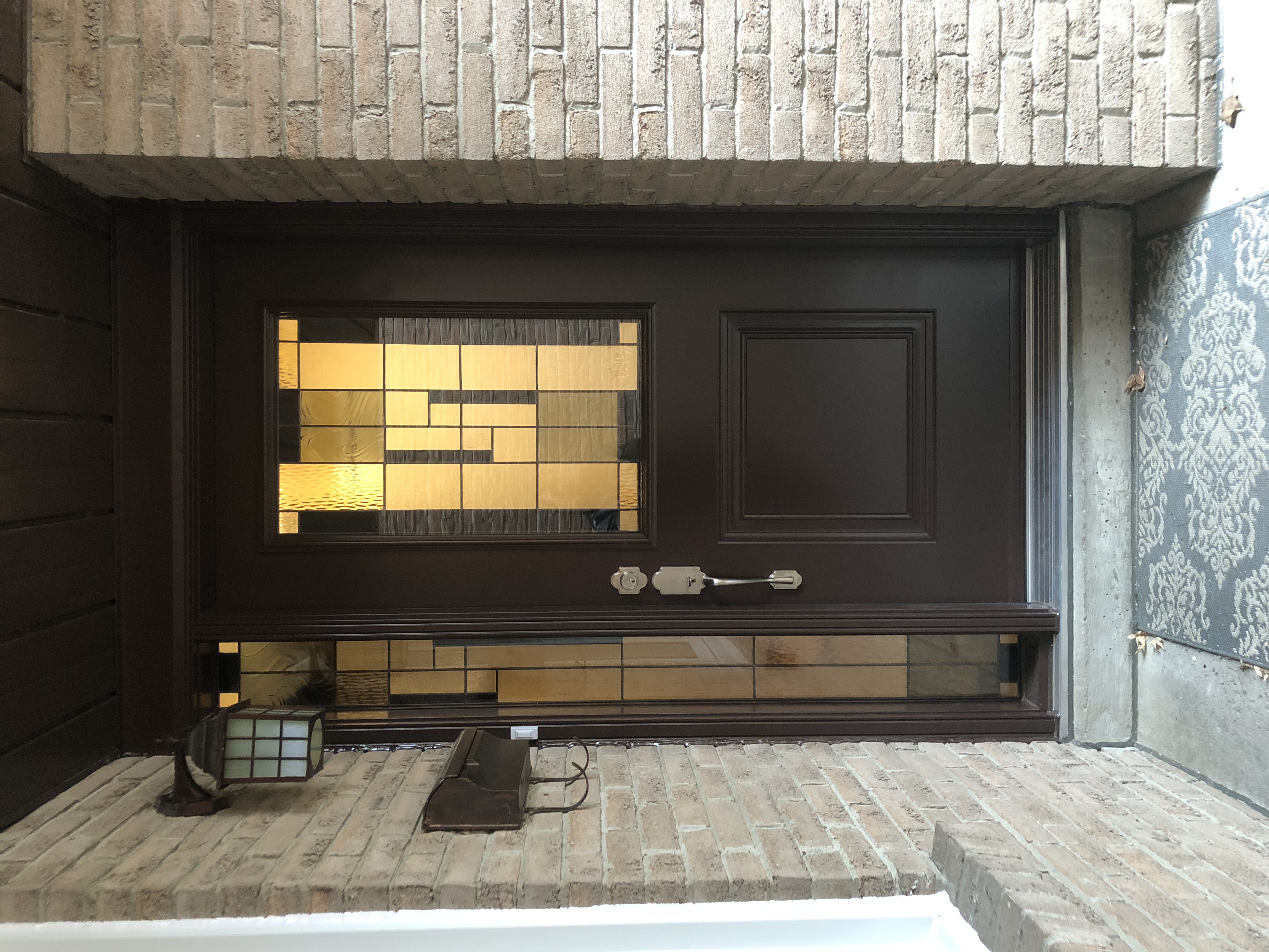 Brown front door with decorative glass inserts, silver hardware, and surrounding brick masonry on a Thornhill home.