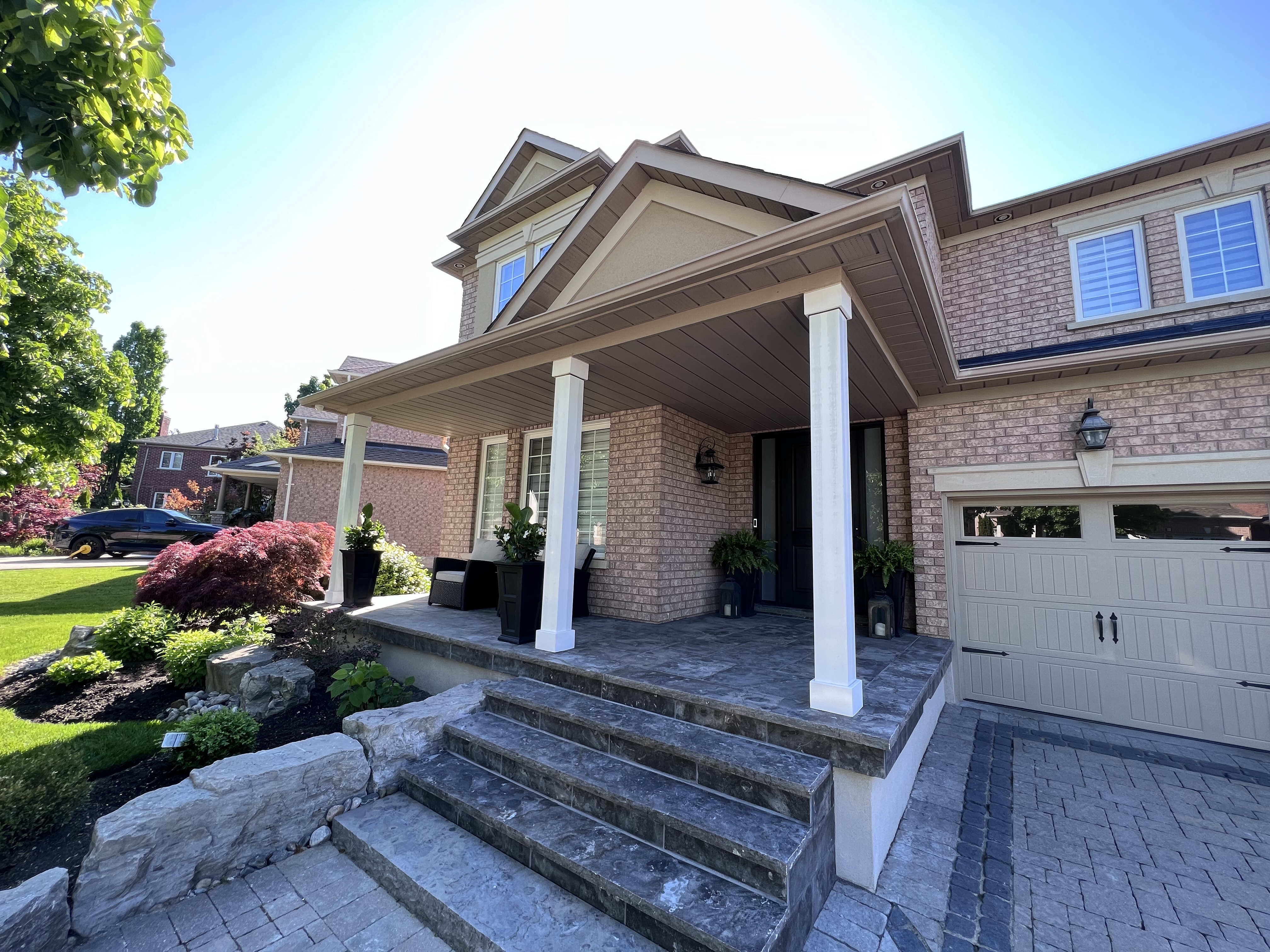 Vaughan home with restored exterior porch columns, stone steps, brick façade, and landscaped front yard.