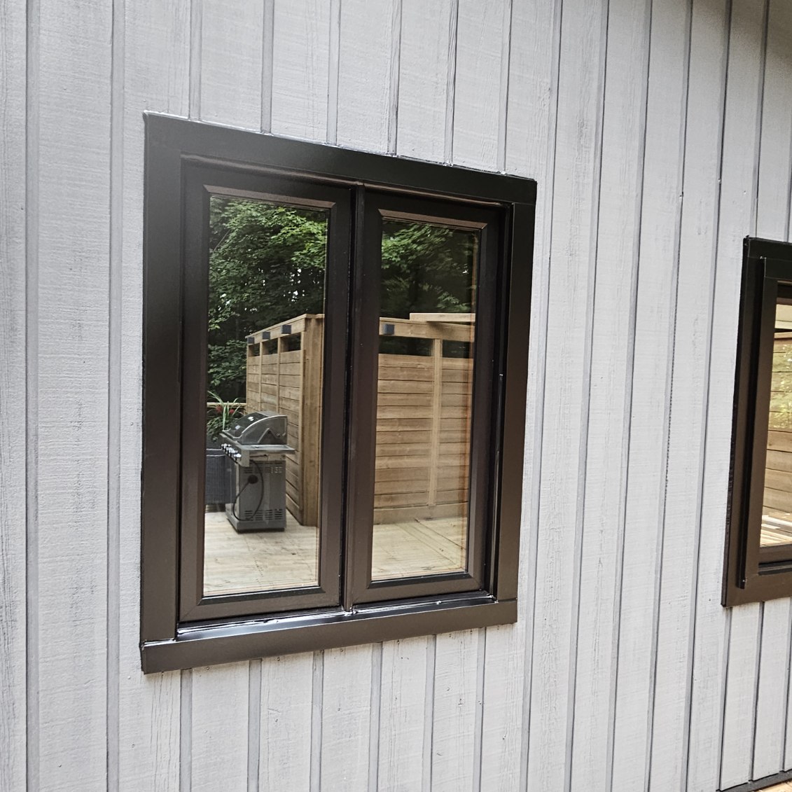 Newly installed energy‑efficient windows on a Queensville home, showing clean exterior siding transitions and window frame.